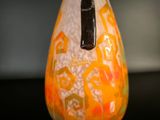 a glass vase with an orange and yellow design on it