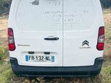 a white van parked in a field with trees in the background