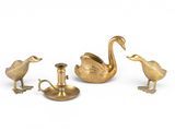 three brass ducks and a candle holder on a white background