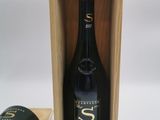 la bouteille de vin se trouve dans une caisse en bois à côté d'une tasse