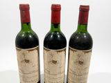 three bottles of wine sitting next to each other on a white surface