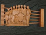 wooden carving of a group of people and a dog on a bench