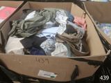 a cardboard box filled with clothes and other items