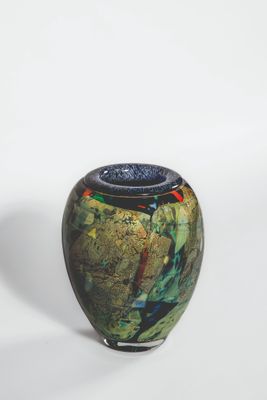 a small vase with a blue lid sitting on a white surface