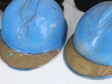 two blue helmets sitting on top of a white table