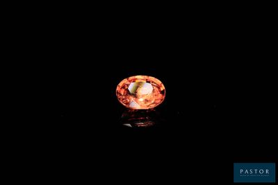 an image of an orange diamond in the dark