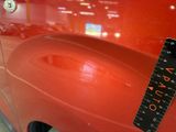 a close up of a red car with a ruler on it ' s side