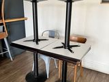 two tables and chairs in a room with a clock on the wall