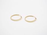 une paire de boucles d'oreilles en or sur fond blanc