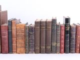 plusieurs vieux livres sont alignés sur une surface blanche
