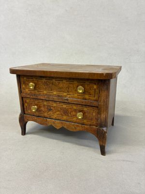 an image of a small wooden chest of drawers on a white background