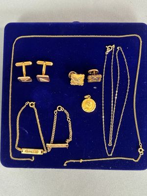 un gros plan sur un plateau bleu sur lequel sont disposés des bijoux en or