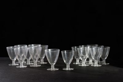 six clear wine glasses are lined up on a black surface
