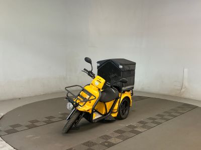 une moto garée dans une pièce, avec un carton à l'arrière