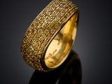 a yellow gold ring with brown diamonds on a black surface
