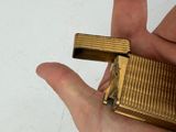 a person holding a gold lighter in their hand