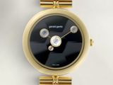 un gros plan d'une montre-bracelet en or avec un cadran noir