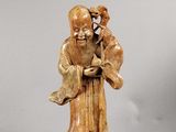 une statue représentant un homme tenant un oiseau sur un socle