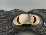 a black leather bow with a gold buckle on it