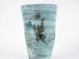 un vase bleu orné d'un dragon, posé sur un fond blanc