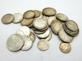 a pile of silver coins on a white surface