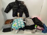 a pile of clothes on a shelf in a closet