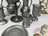 a lot of pewware on a table with a silver plate