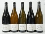 six bouteilles de vin sont alignées sur une table