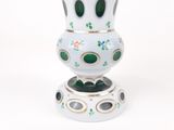 un vase blanc orné de motifs verts et dorés