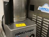 un robot assis dans une cuisine, à côté d'une poubelle