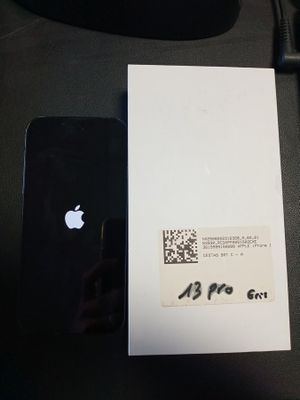 un iPhone noir posé sur un bureau, à côté d'une feuille de papier blanche