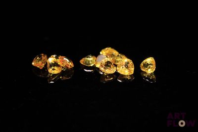 a close up of a group of yellow diamonds sitting on top of a black surface