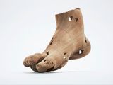 une sculpture en bois représentant un pied percé de trous