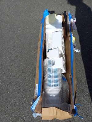 une personne à vélo avec un carton à l'arrière