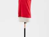 un haut rouge posé sur un mannequin monté sur un pied