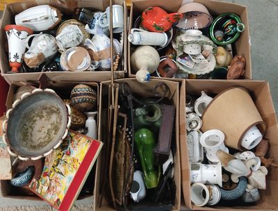 des cartons remplis d'objets divers posés à même le sol