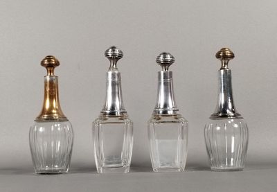 trois bouteilles en verre avec des bouchons argentés et un bouchon doré posées sur une table