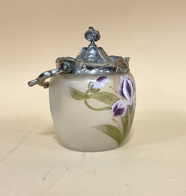 un vase blanc orné de fleurs violettes, posé sur une table