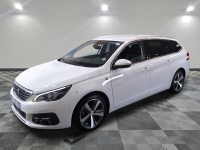 une voiture blanche est garée dans une pièce au sol à carreaux