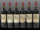six bottles of wine are lined up in a row on a table