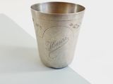a silver cup with writing on it sitting on a table