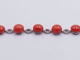 a close up of a row of red beads on a white surface