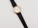 a close up of a wrist watch on a white surface