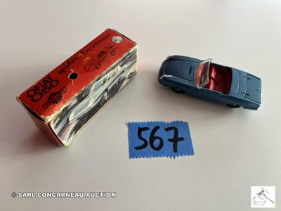une petite voiture miniature posée à côté d'une boîte sur laquelle est collé un autocollant