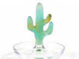 a glass bowl with a cactus in it on a white surface