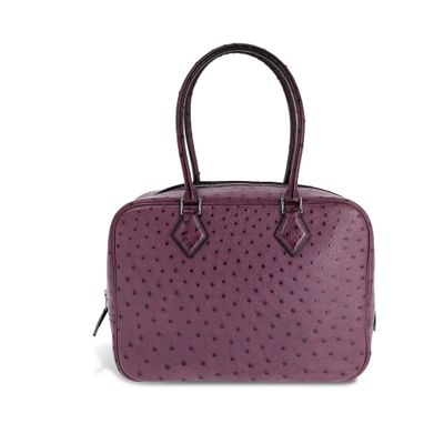 un sac à main en cuir d'autruche violet sur fond blanc
