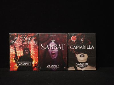 Trois livres de la série sur les vampires sont alignés sur une surface noire