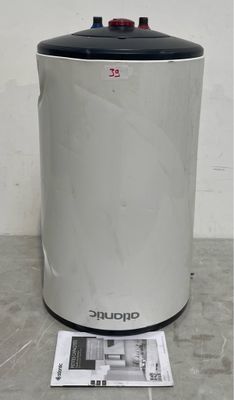an electric water heater sitting on top of a table next to a newspaper