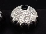 two black and white vases sitting next to each other