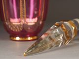 a bottle of perfume sitting next to a glass vase